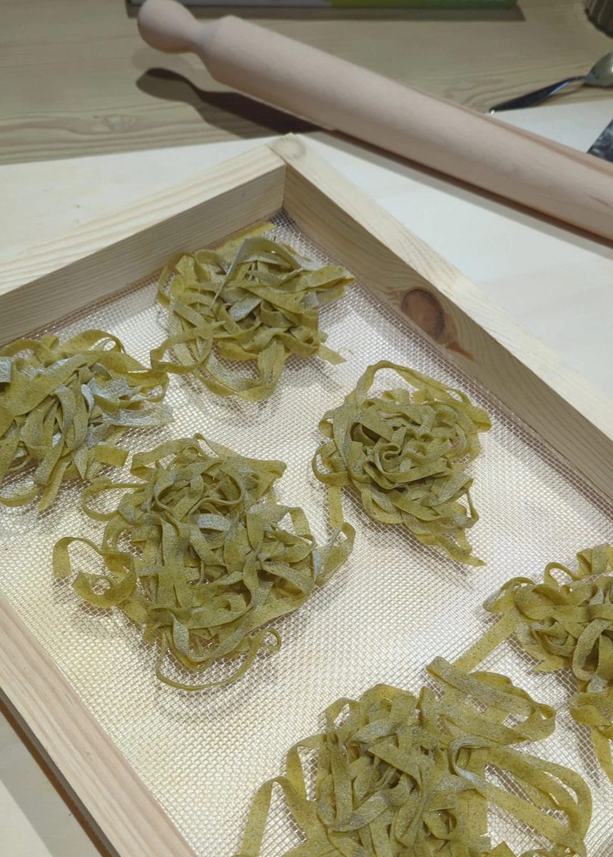 Nettle tagliatelle nests drying on a wooden frame at davVero